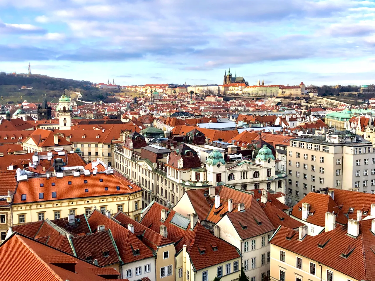 Red rooftops of Prague's Old Town under a blue sky