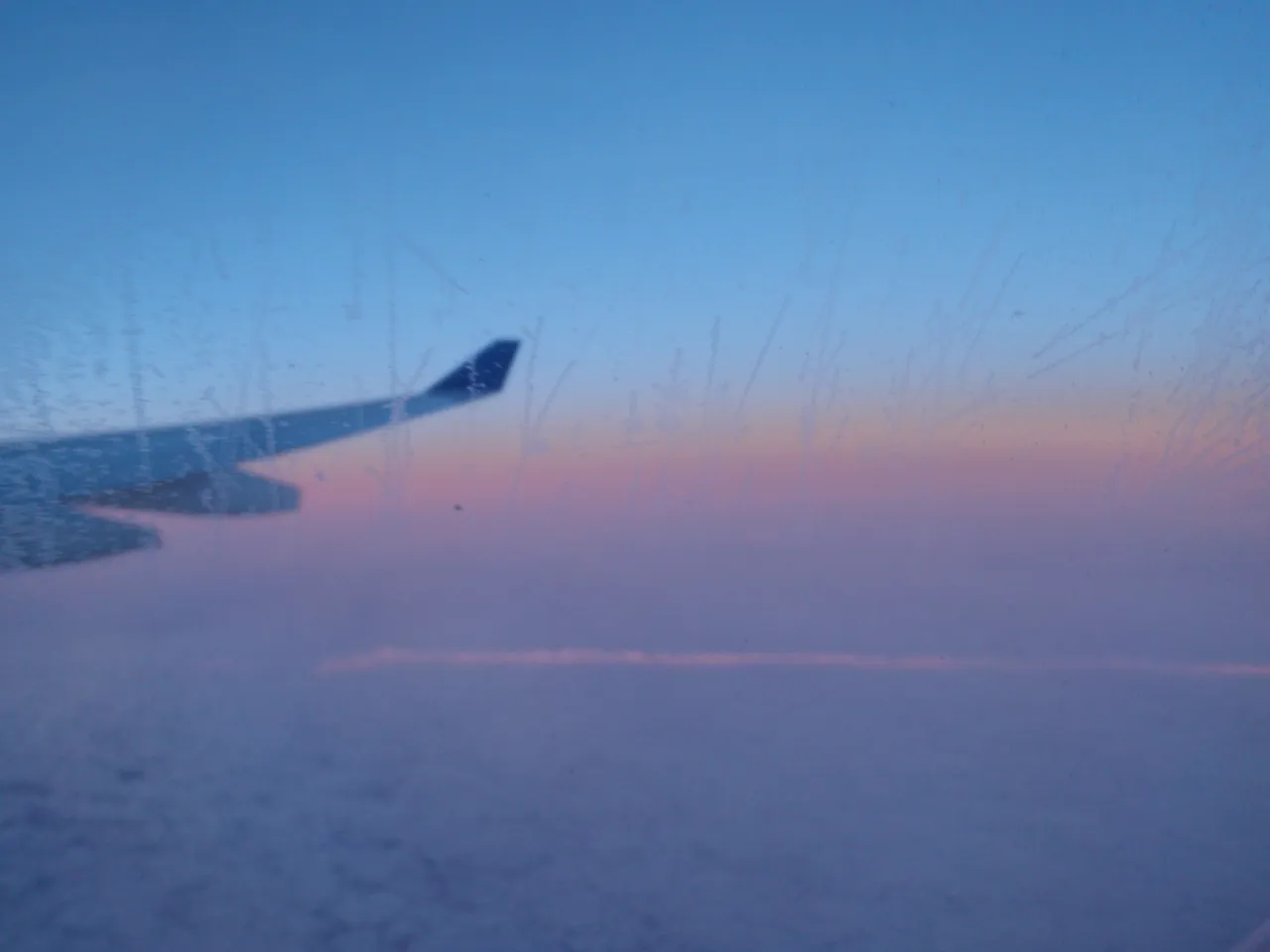 Dawn above the clouds seen from an airplane window